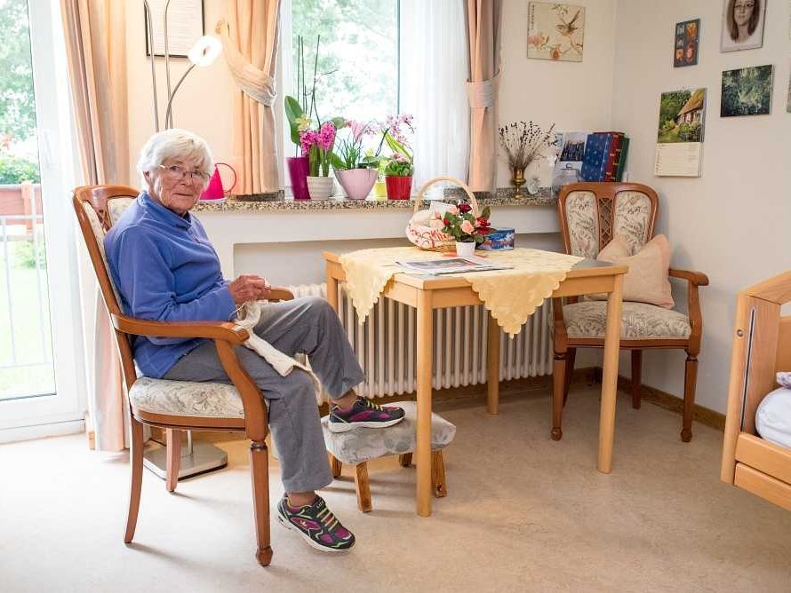 Eine Bewohnerin in ihrem Zimmer beim Stricken